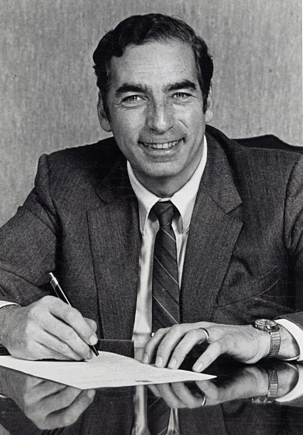 A photo of Bertram S. Brown, MD writing at a desk.