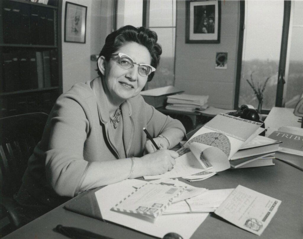 A photograph of Gisela Knopka, DSW at her desk, writing